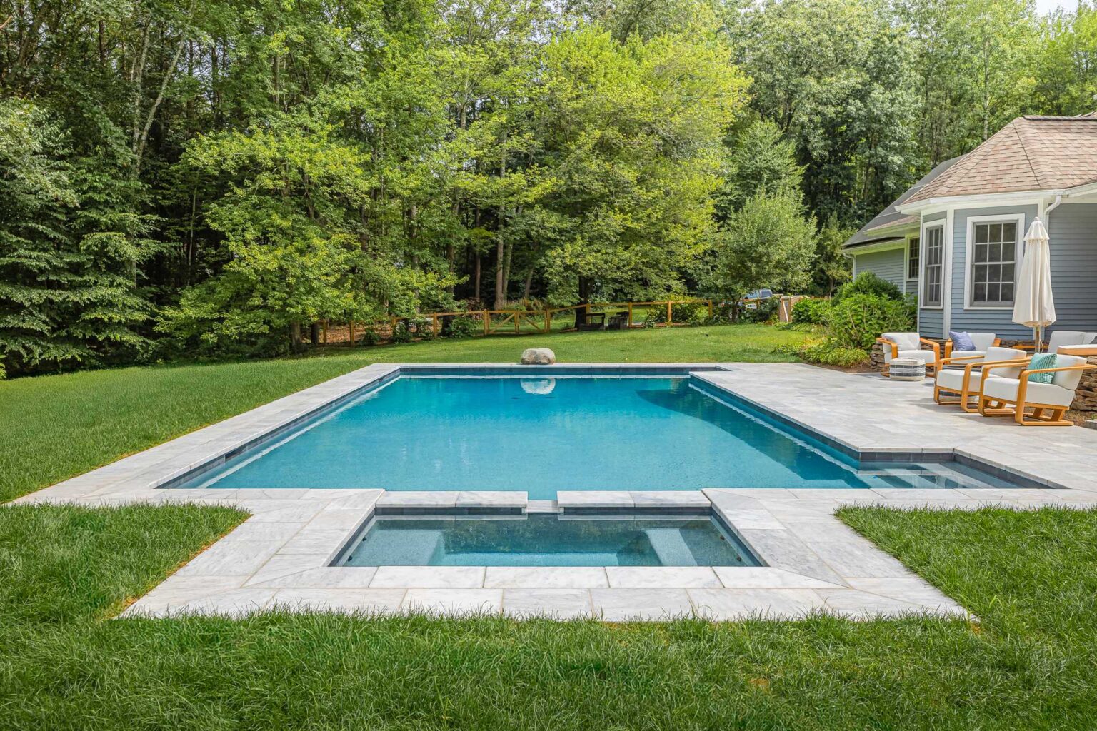 Porcelain stone patio surrounding swimming pool built by Bahler Brothers in Easthampton, Massachusetts