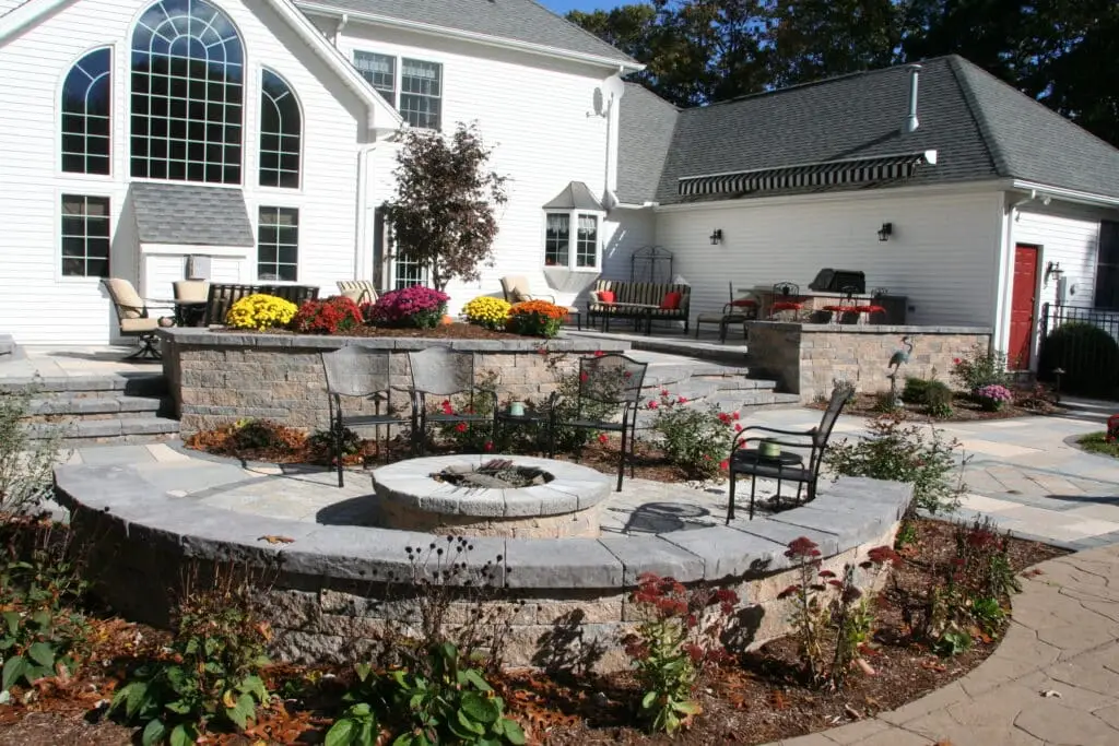 Custom paver patio with sitting wall, retaining wall, and landscape design and plantings built by Bahler Brothers