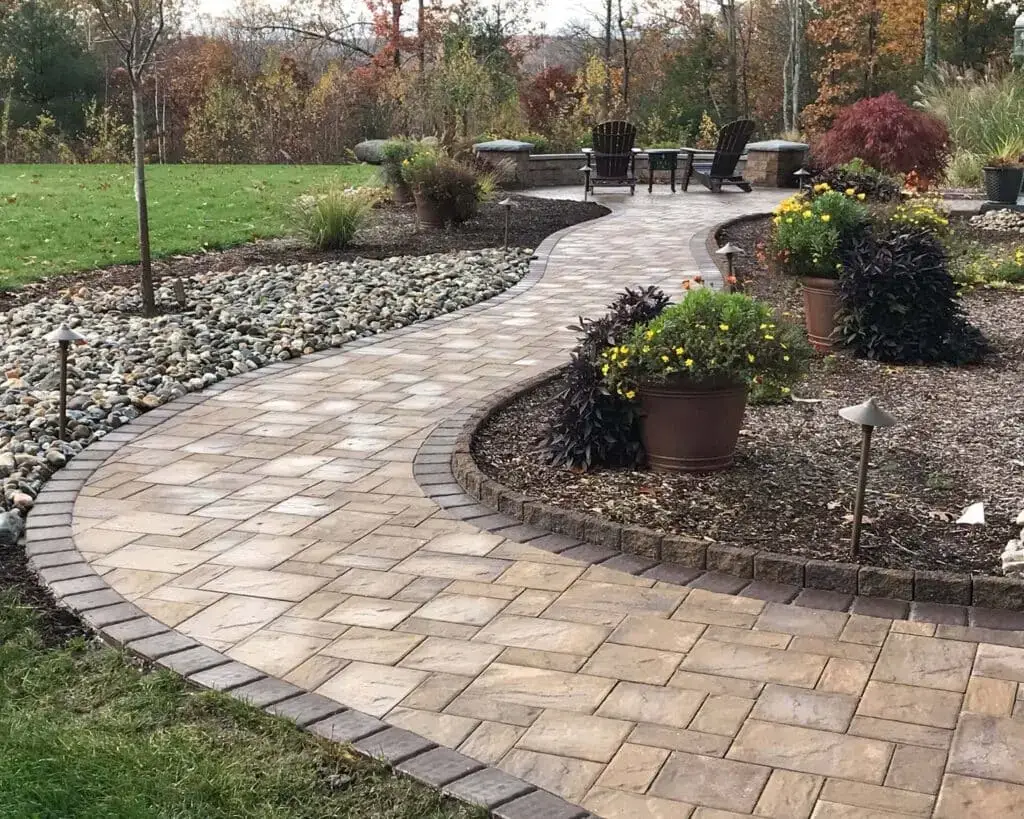 Paver walkway with landscape lighting leading to the front of the house by Bahler Brothers